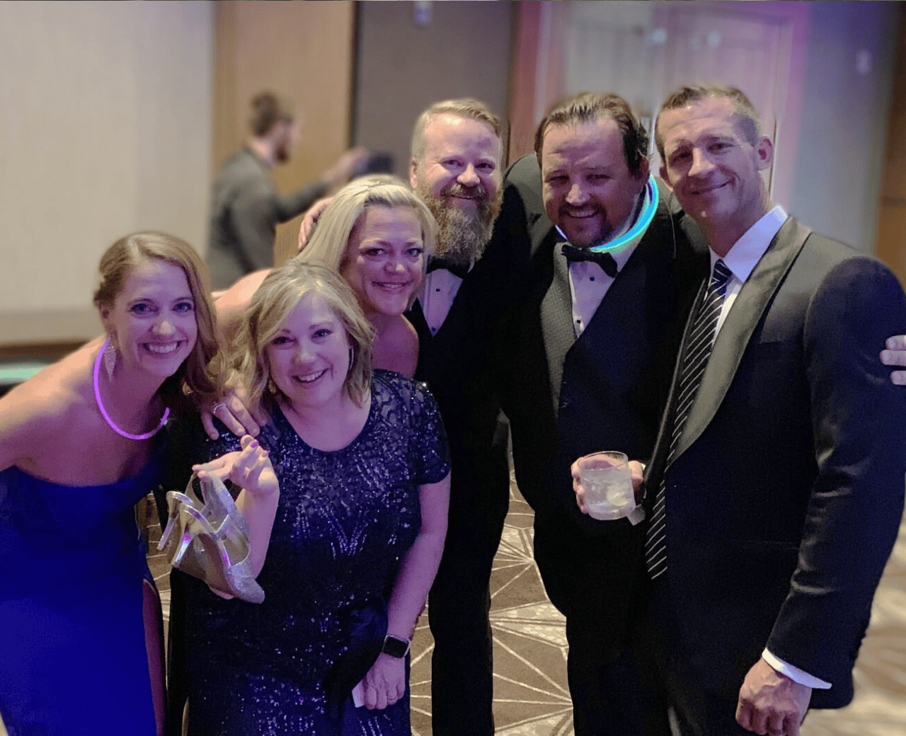 A group of men and women posing for a photo at a formal event.