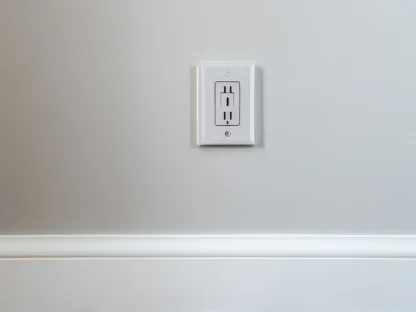 A white electrical outlet on a light gray wall above a wooden floor.
