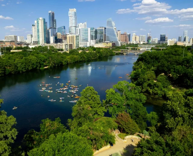 Aerial view of kayakers in Lady Bird Lake with the Austin skyline in the background