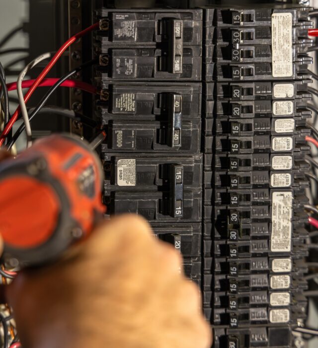 A residential electrician doing electrical repairs on a faulty circuit breaker in college station, tx