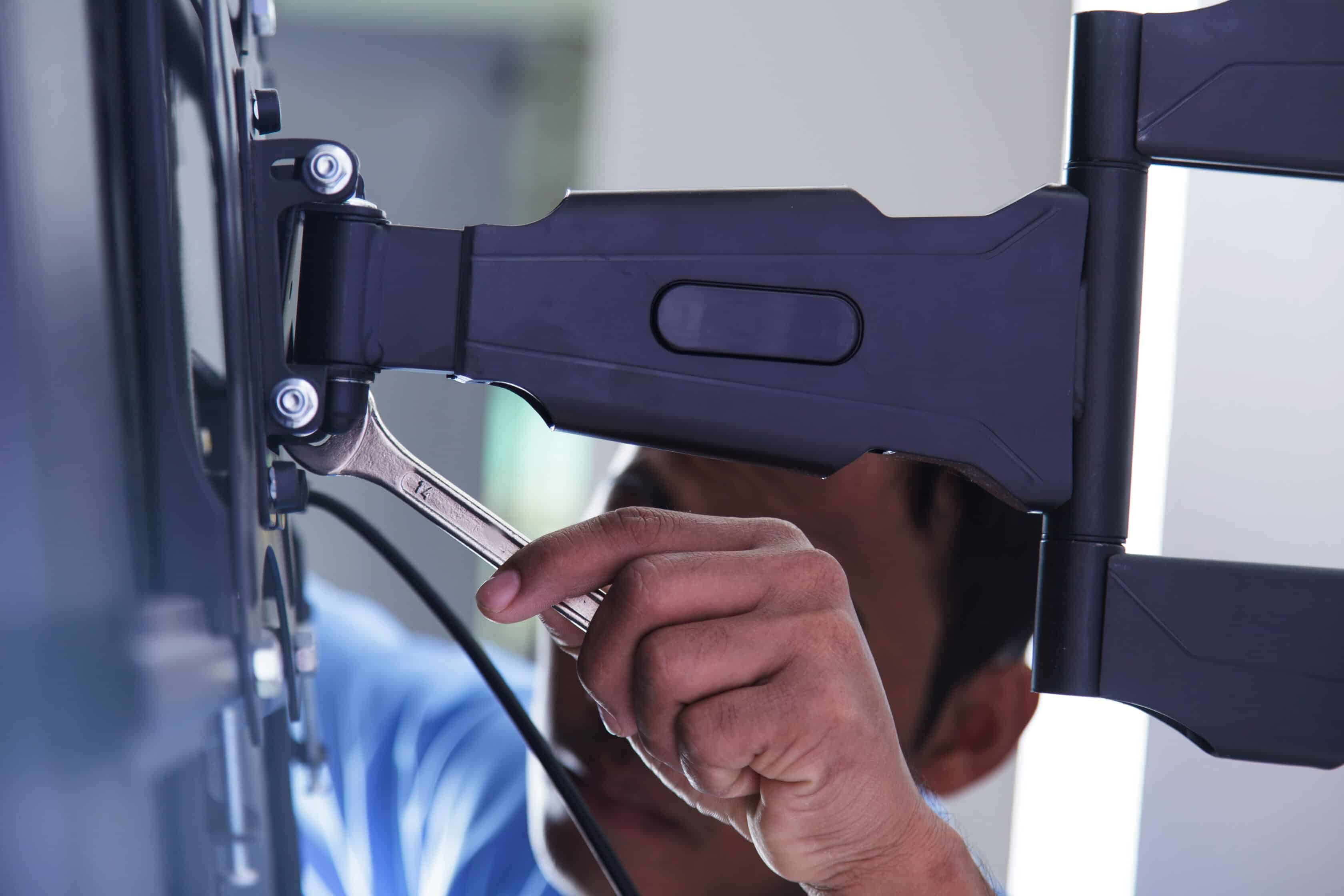 Technician Installing a TV Mount to Hang a Large Flatscreen TV to the Wall